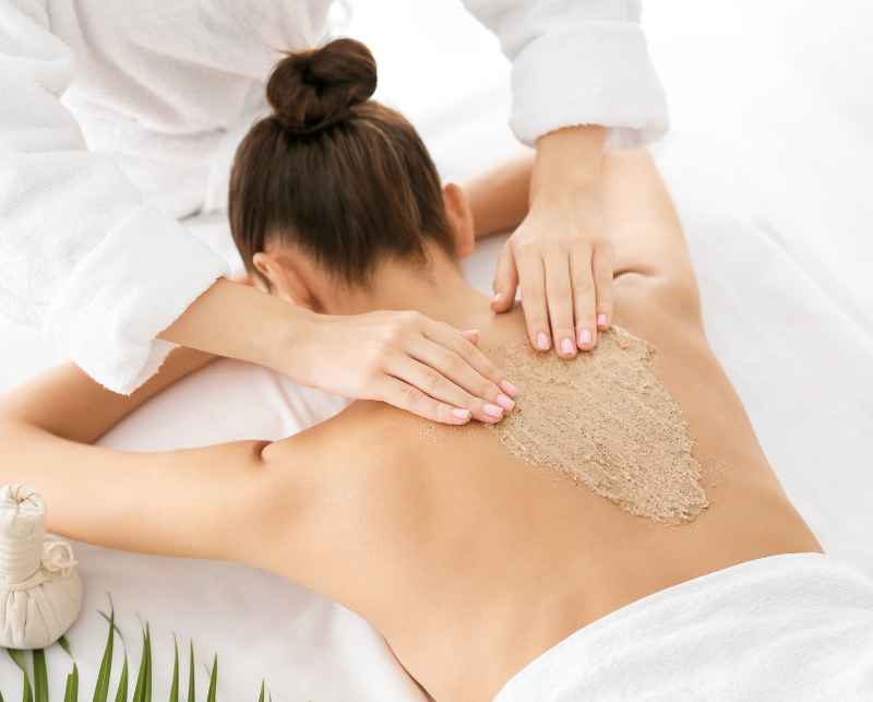 Peeling cukrowy podczas zabiegu nawilżającego na ciało w SPA Velissi.