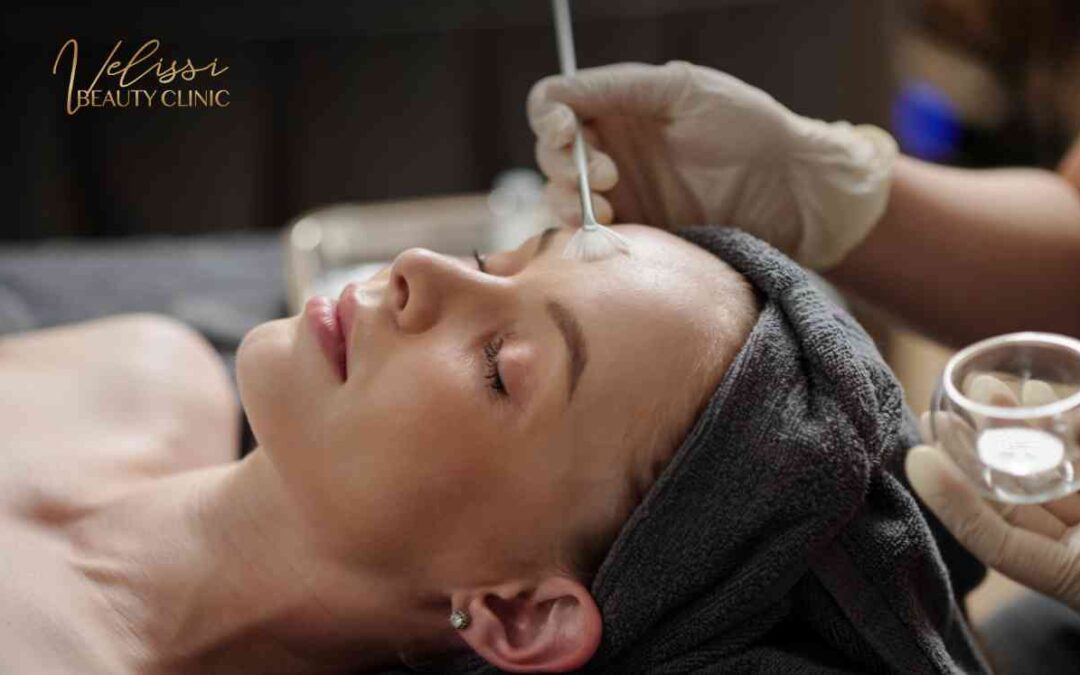 Klientka w opasce podczas nakładania peelingu chemicznego wachlarzowym pędzlem w gabinecie Velissi.